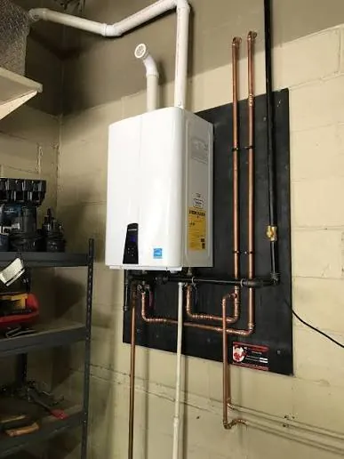 Navien tankless water heater installed in a utility closet by Grizzly Plumbing